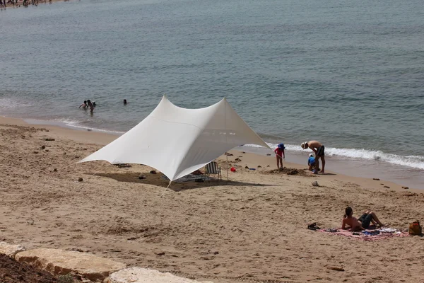 TEL AVIV, ISRAEL - MARÇO 16: Desconhecido na praia em Tel Baruch, local de férias favorito, no início da temporada de natação em 16 de março de 2013 em Tel Aviv, Israel . — Fotografia de Stock