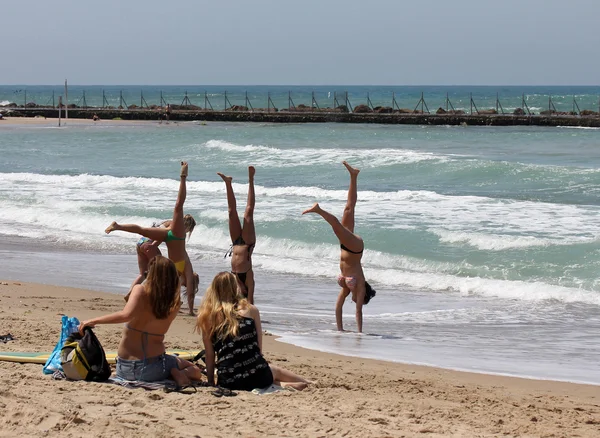 Meisjes doen acrobatiek op het strand — Stockfoto