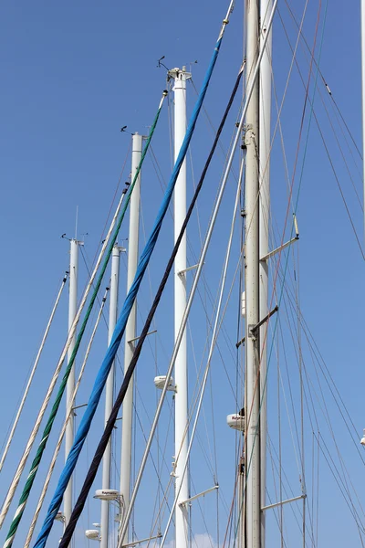 Mastsna av yachter på blå himmel bakgrund — Stockfoto