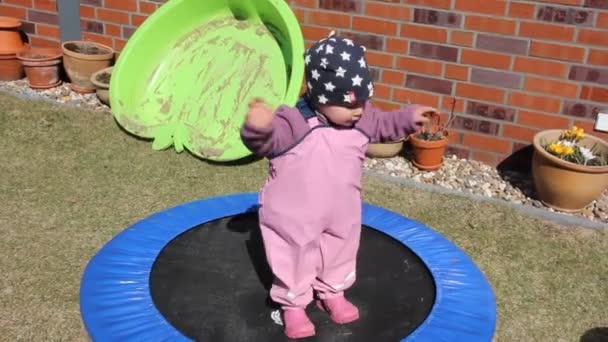 Kleines Mädchen versucht auf dem Trampolin zu springen — Stockvideo