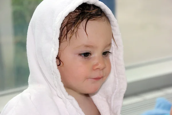 Little girl (one year and six months of age) in a white robe after a swimming pool — Stockfoto