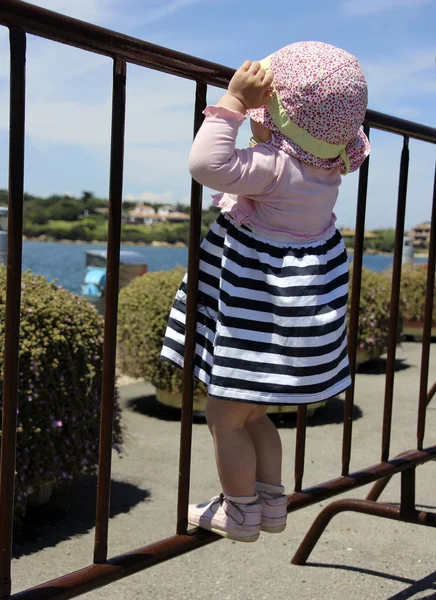 Kleines nettes blondes Mädchen am Hafen in porto cervo. Sardinen — Stockfoto