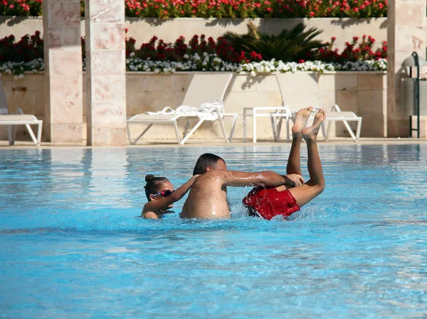 Vader speelt met de kinderen op het water — Stockfoto