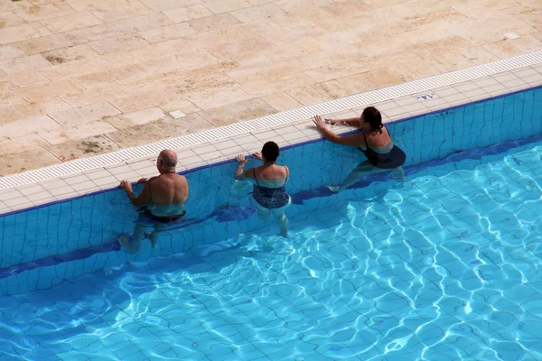 Group of tourists take water treatments at swimming pool by the Dead sea — Stock Photo, Image