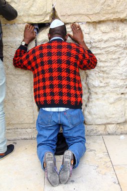 JERUSALEM, ISRAEL - DECEMBER 9: Jewish worshiper prays at the Wailing Wall an important jewish religious site at winter on December 9, 2013 in Jerusalem, Israel clipart