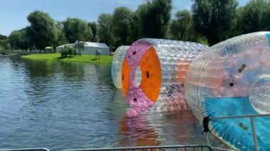 Münih, Bavyera, Almanya. Olimpiyat parkı. Çocuklar için eğlence, lunapark gezileri. Yüzen plastik su varilleri. Çocuklar zorlaşıyor. 4K