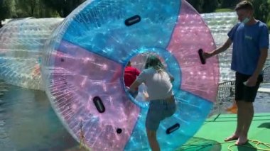 Münih, Bavyera, Almanya 25 Temmuz 2021 Olimpiyat Parkı. Çocuklar için eğlence, lunapark gezileri. Yüzen plastik su varilleri. Çocuklar zorlaşıyor. 4K