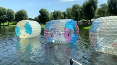 Münih, Bavyera, Almanya. Olimpiyat parkı. Çocuklar için eğlence, lunapark gezileri. Yüzen plastik su varilleri. Çocuklar zorlaşıyor. 4K