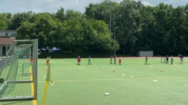 Münih, Almanya - 25 Temmuz 2021: Küçük futbol oyuncularının yapay sentetik bir sahada eğitilmesi. 4K