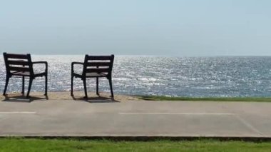 Tropikal sakin deniz arka planında iki sandalye. 4K