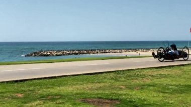 Tropikal sakin deniz arka planında üç tekerlekli bisiklet gezintisi. HD