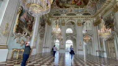MUNICH, GERMANY - 25 Ağustos 2021: Barok tarzı Nymphenburg sarayının en güzel salonlarından birinde turistler. 4k.