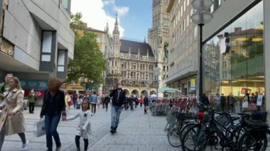 Münih, Almanya - 14 Ağustos 2021: Marienplatz Meydanı 'ndaki belediye binasının önündeki turistler. Mary 'nin meydanı ve güneşli bir günde New Town Hall. 4K