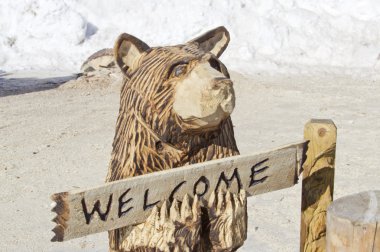 Black Bear with Welcome Sign Wood Carving Statue clipart