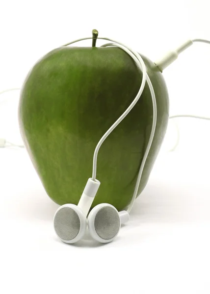 Maçã verde com fones de ouvido — Fotografia de Stock