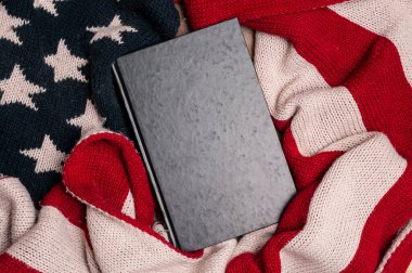 Amerika Birleşik Devletleri 'nin yün bayrağına sarılı boş kapaklı eski bir kitap.