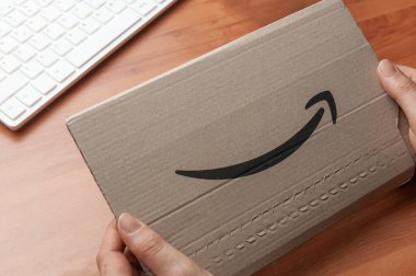 Carrara, İtalya - 16 Şubat 2022 - Kadın elinde Amazon Marketi logosu olan bir zarf tutuyor