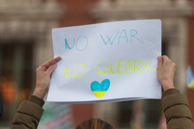 Sahip, İtalya - 26 Şubat 2022 - Bir kadın Ukrayna 'nın işgaline karşı düzenlenen gösteride İngilizce ve İtalyanca Savaş Yasağı işareti gösteriyor