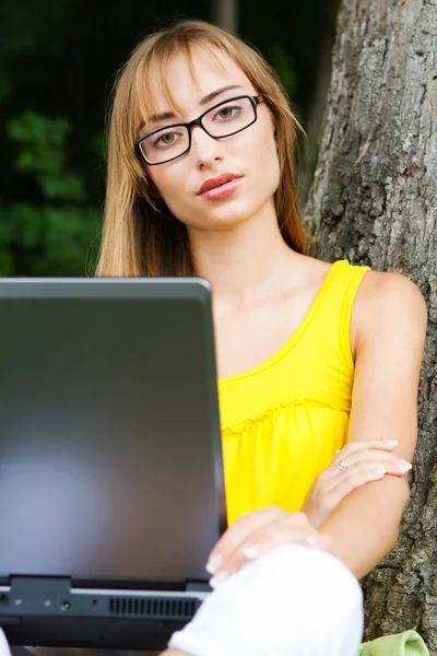 Potret close-up seorang wanita muda dengan laptop terhadap backgro — Stok Foto