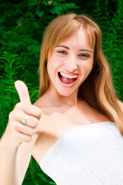 Smiling young woman lifts thumb — Stock Photo, Image