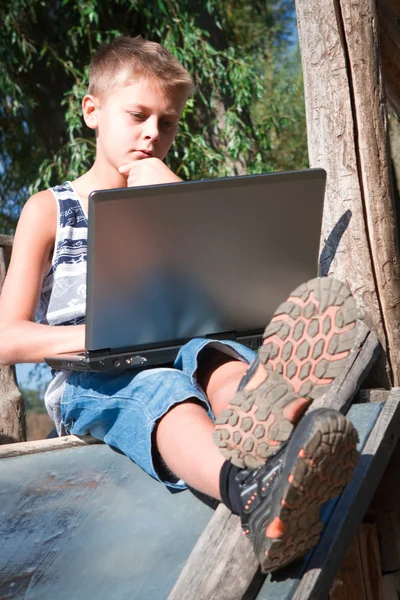 Niño con portátil en la naturaleza — Foto de Stock