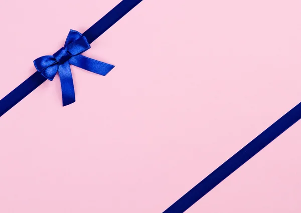 Blue ribbon bow on pink background — Stock Photo, Image