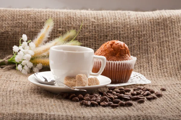 Cup of coffee, grains on burlap background — Stock Photo, Image