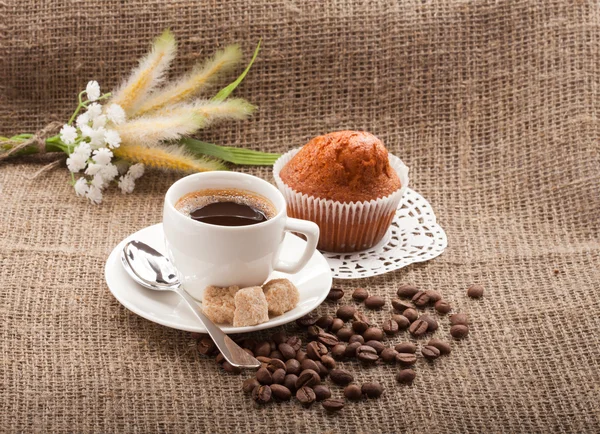 Cup of coffee, grains on burlap background — Stock Photo, Image