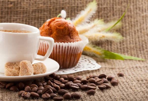 Xícara de café, grãos no fundo da serapilheira — Fotografia de Stock