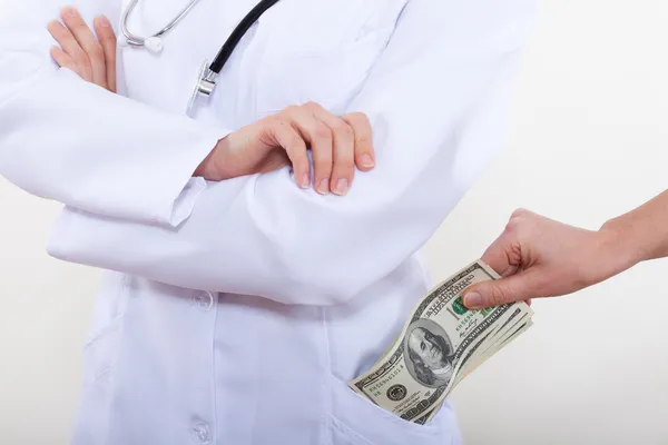 O paciente coloca dinheiro no seu médico de bolso . — Fotografia de Stock