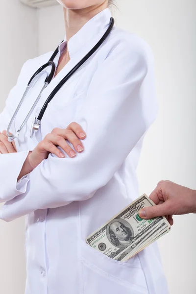 Пациент кладет деньги в карман врача . — стоковое фото