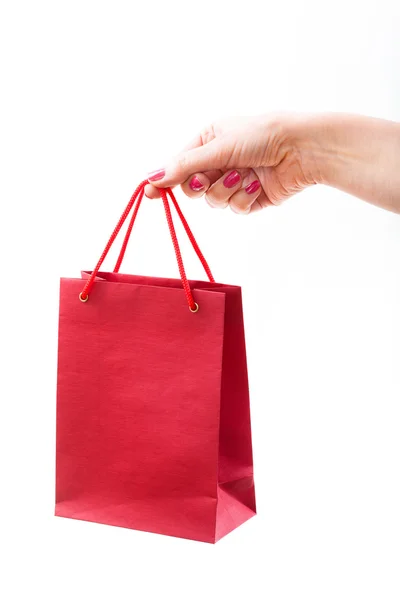 Red paper bag in female hand — Stock Photo, Image