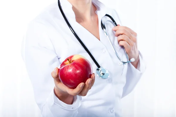 Female doctor giving red apple — Stock Photo, Image