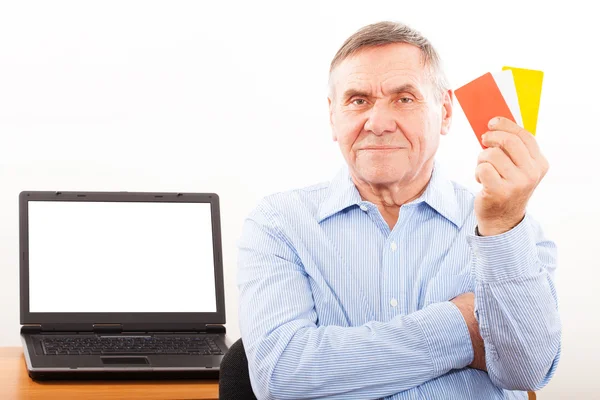 Пожилой человек улыбается и показывает кредитку — стоковое фото