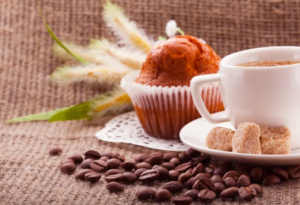 Cup of coffee, grains on burlap background — Stock Photo, Image