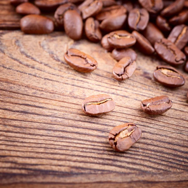 Granos de café en textura de madera — Foto de Stock