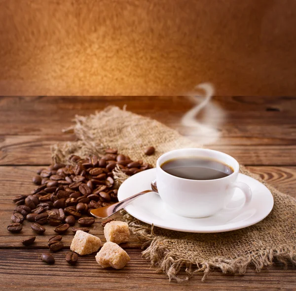 Filiżanka kawy i spodek na drewnianym stole. — Zdjęcie stockowe
