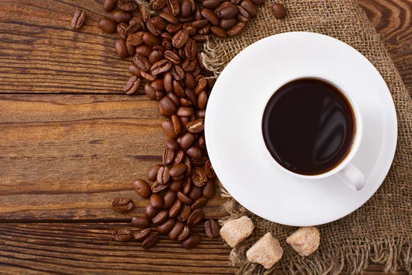 Xícara de café e pires na mesa de madeira. — Fotografia de Stock