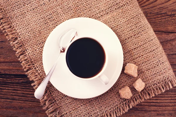 Kaffekopp och fat på träbord. — Stockfoto