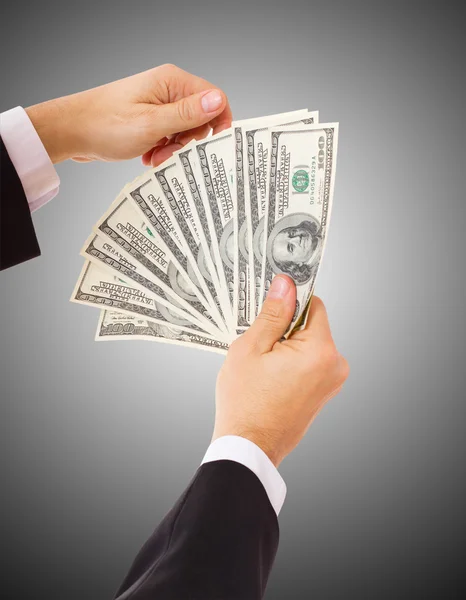 Businessman giving cash dollars in the hands — Stock Photo, Image