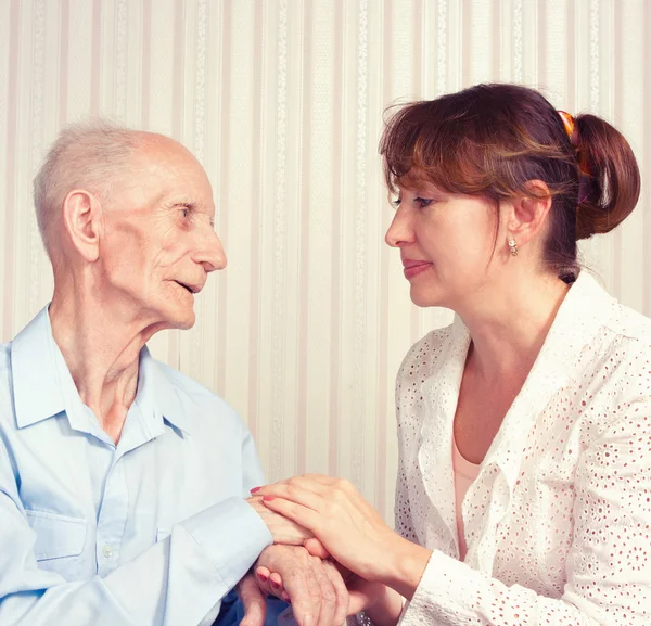 Senior man, vrouw met hun verzorger thuis. — Stockfoto