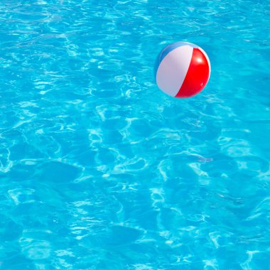 Inflatable colorful ball floating in swimming pool clipart
