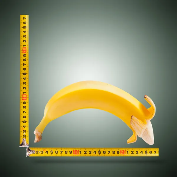 Large banana and measuring tape — Stock Photo, Image