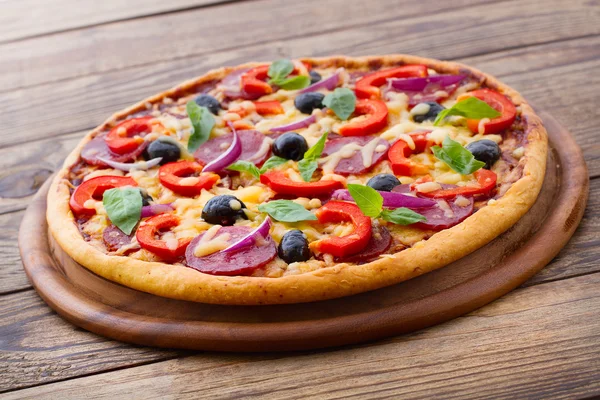 Lahodná čerstvá pizza podávaná na dřevěném stole. — Stock fotografie