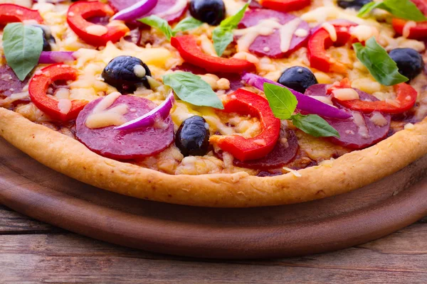 Deliziosa pizza fresca servita sul tavolo di legno. — Foto Stock
