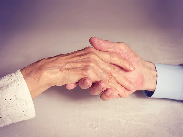 Oude mensen houden handen close-up. — Stockfoto