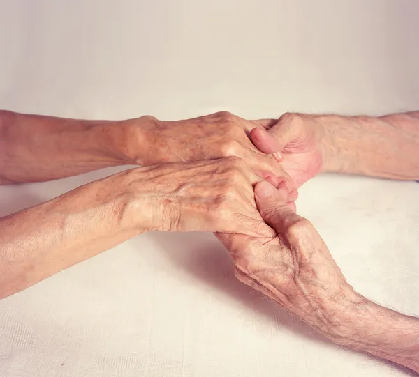 Starzy ludzie trzymając ręce zbliżenie. — Zdjęcie stockowe