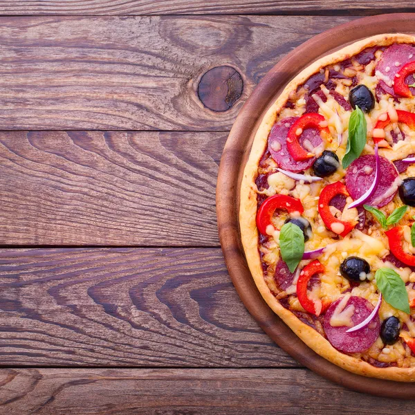 Deliciosa pizza fresca servida en mesa de madera. — Foto de Stock