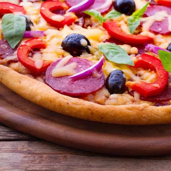 Leckere frische Pizza auf Holztisch serviert. — Stockfoto
