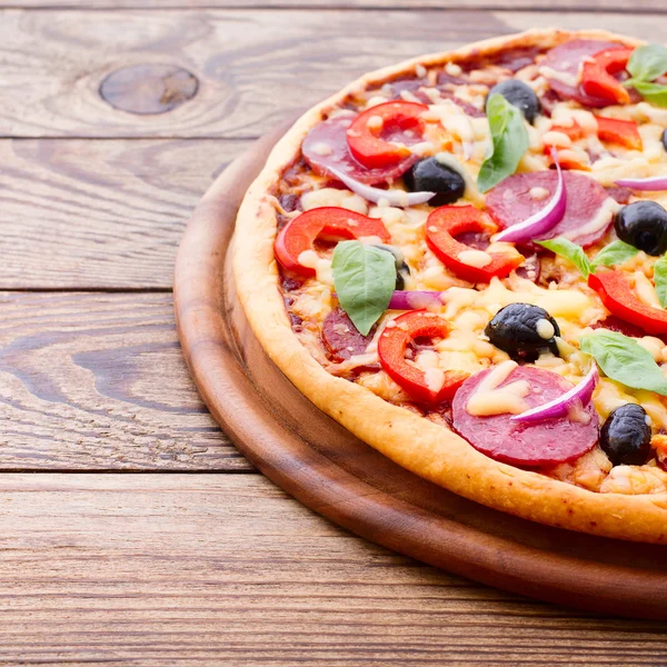 Deliciosa pizza fresca servida em mesa de madeira. — Fotografia de Stock